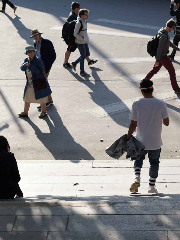 People in different ages, walking in an urban area.
