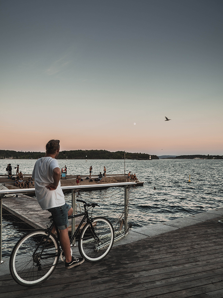Young man on a bicycle by the sea in the Oslo area.