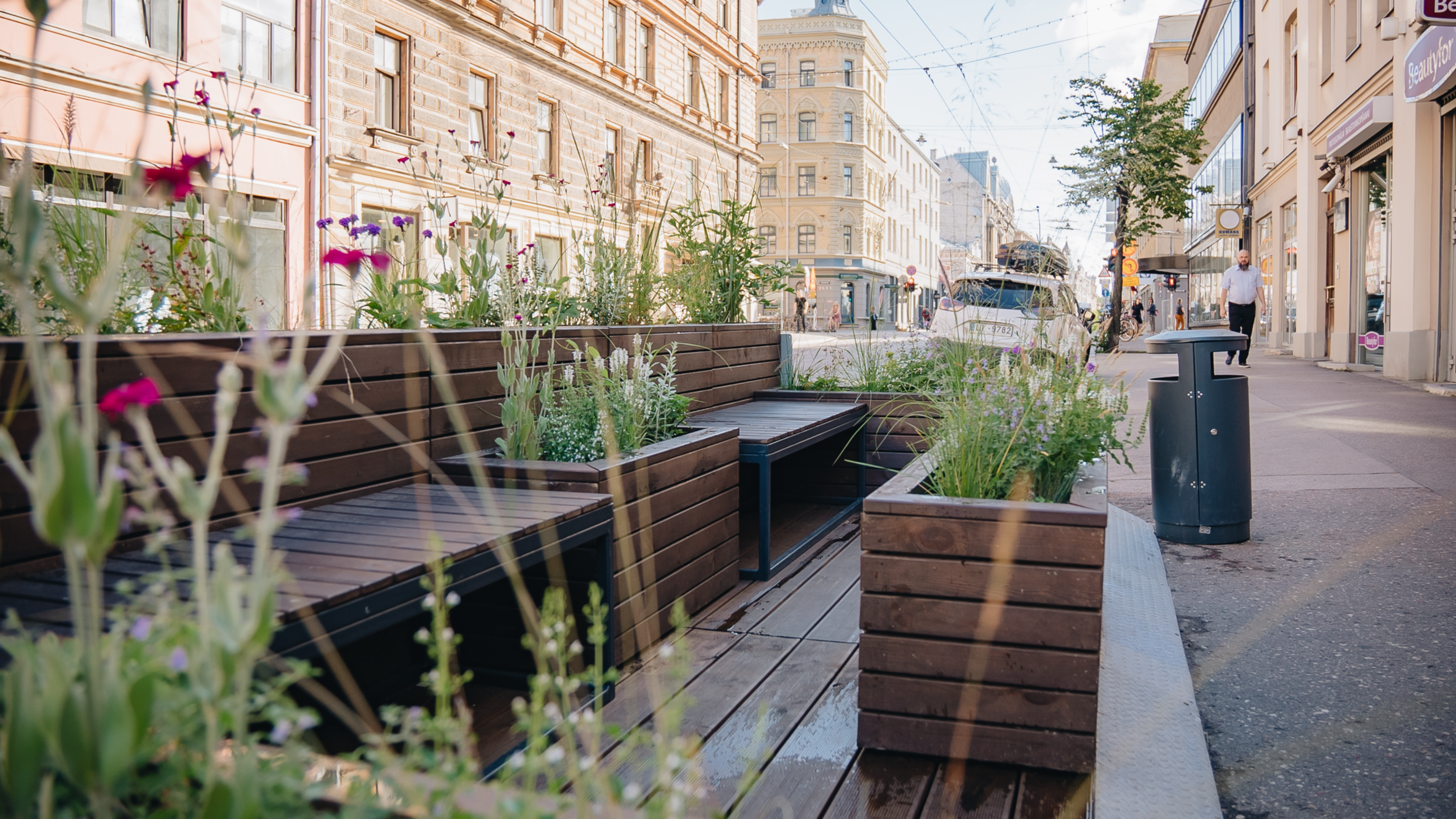A wooden construction to replace a parking space with greenery and resting places in Riga.