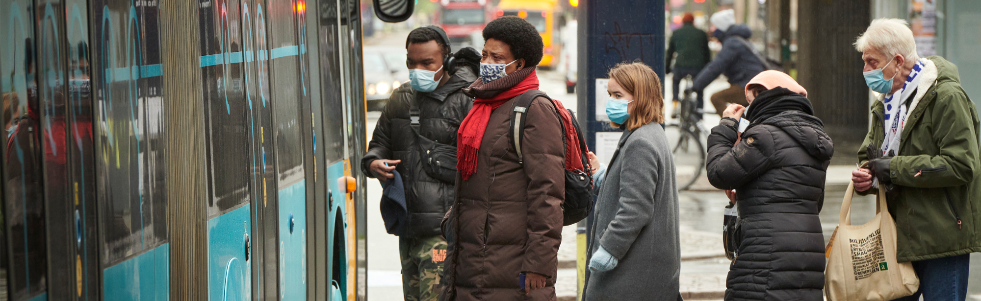 People with masks waiting for the bus