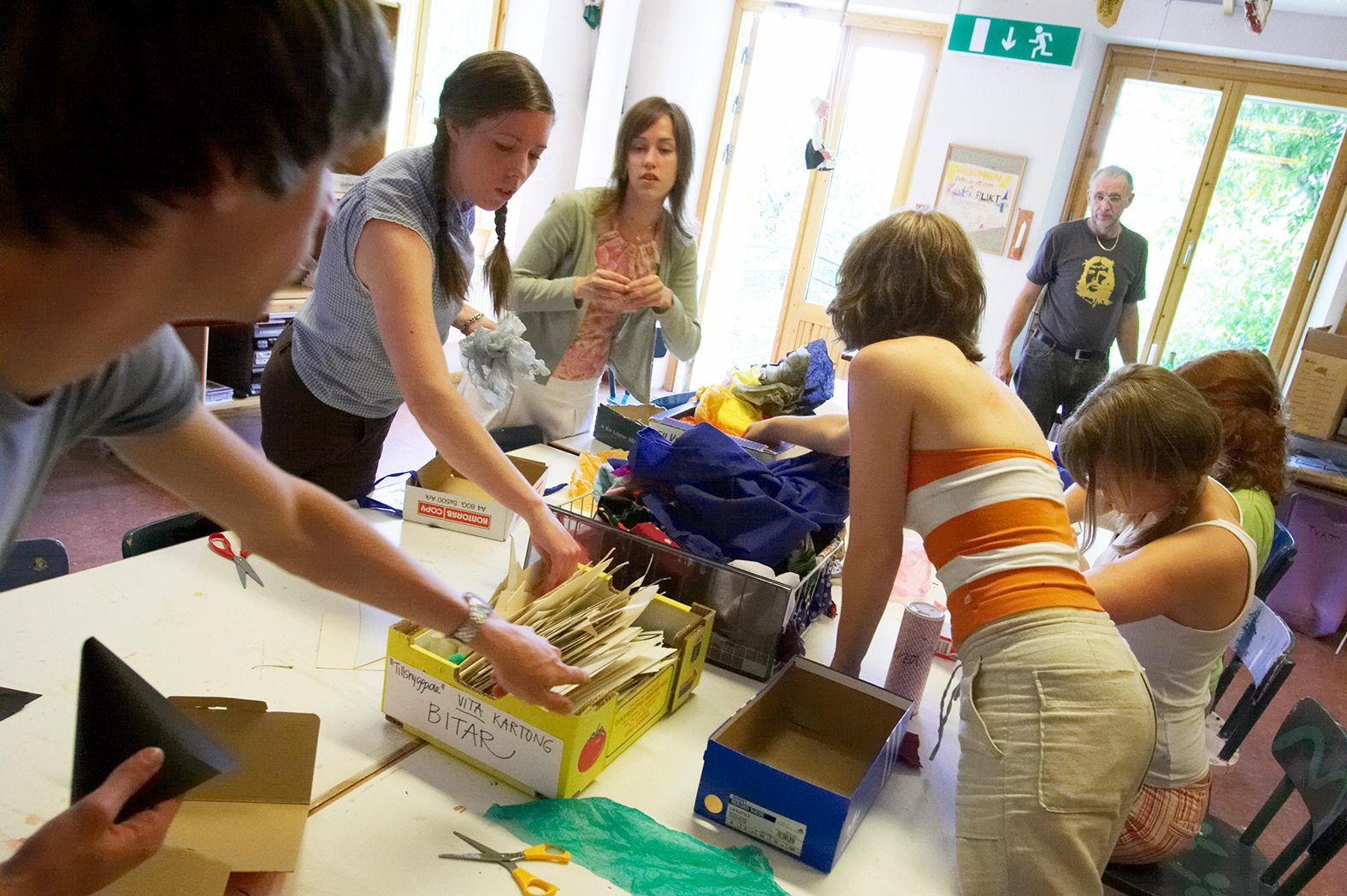 Young people creating things with papers and scissors