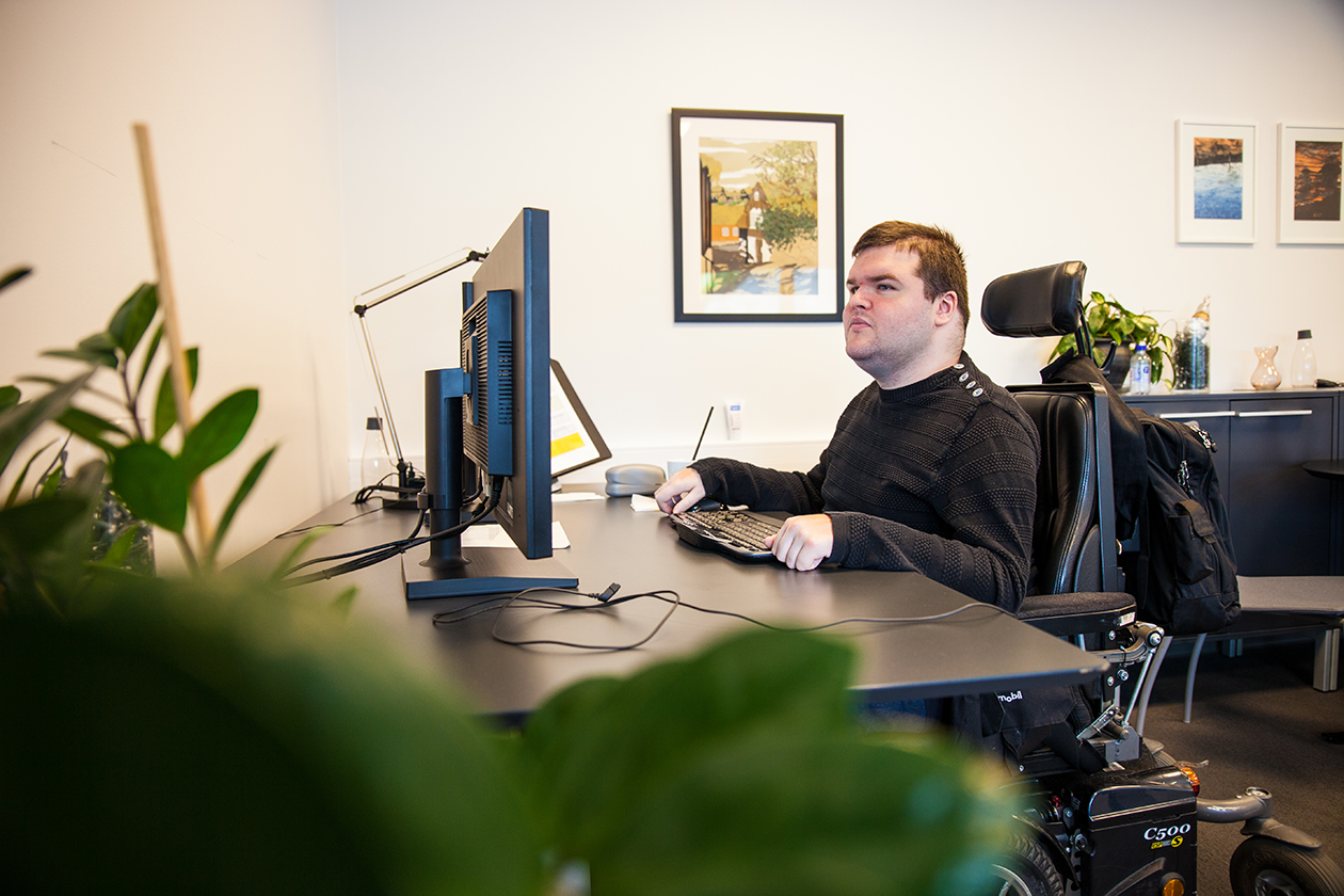 Young man in wheel chair in front of computer