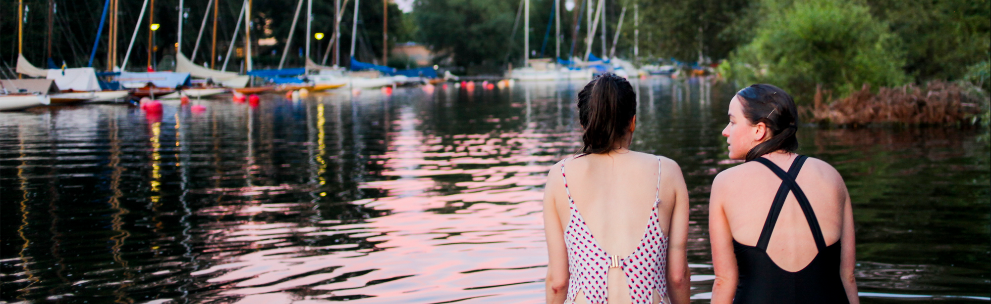Two girls in swimming clothes at a pier